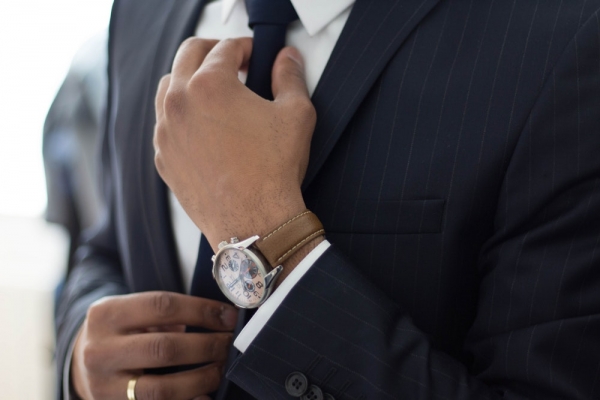 Close-up of a businessman's hands adjusting his tie