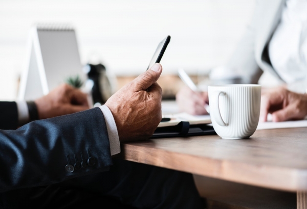 person holding smartphone on table