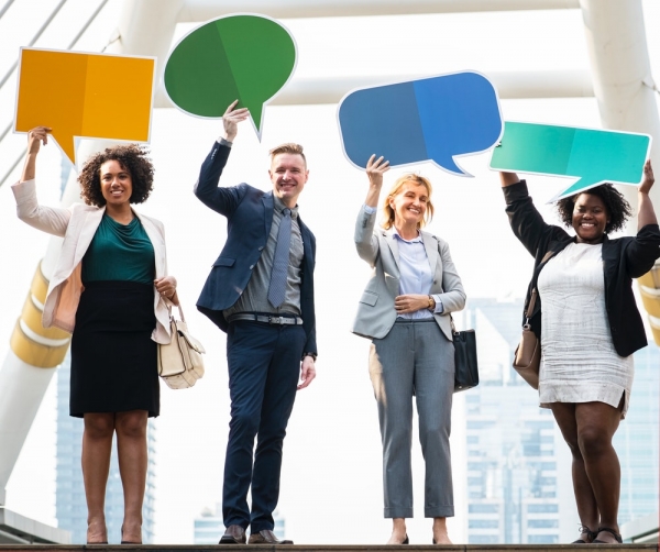 four people holding bubble chat boards