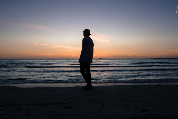 man standing on beach shore during daytime