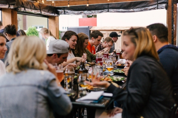 people sitting in front of table talking and eating