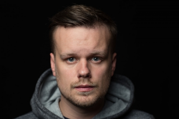 man wearing gray pullover hoodie in a dark room