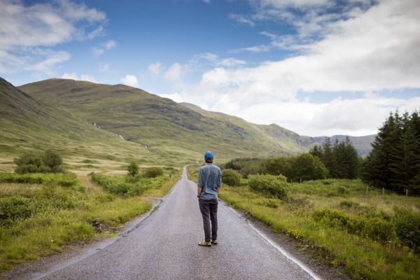 man standing on concrete road