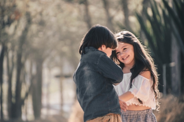 selective focus photography of boy and girl standing next to each other