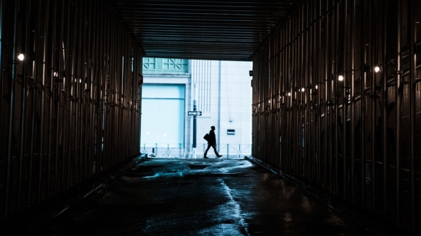 person walking in front of tunnel