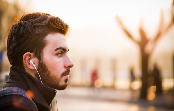 bokeh lights photography of man listening to in-ear earphones