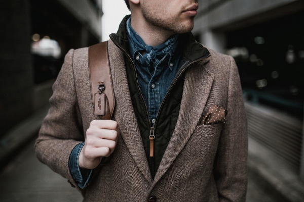 man in pown suit jacket carrying pown backpack